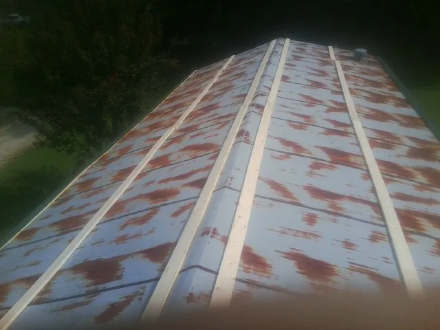 Rusted metal roof panels with new wood purlins before replacement — Storm Damage Roof Repair in Coalport by Roofing Brothers