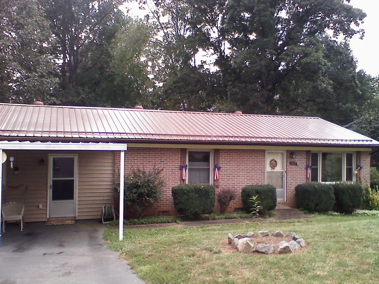 Bronze metal roof and carport on a brick ranch home — Roof Repair work by our crew in Coalport